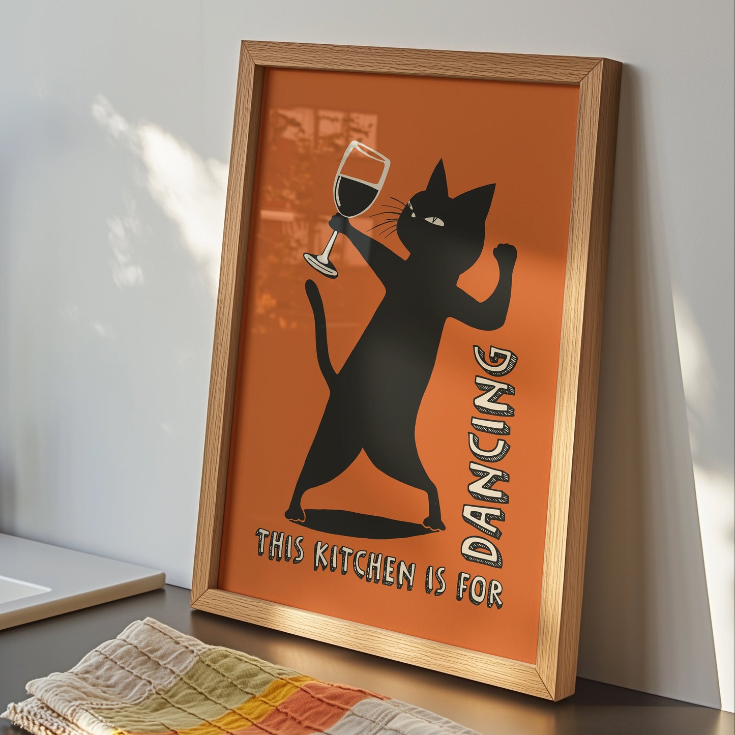 Retro illustration of a sassy black cat dancing while holding a wine glass on a burnt orange background, text reads "This Kitchen is for Dancing" in a vintage font.