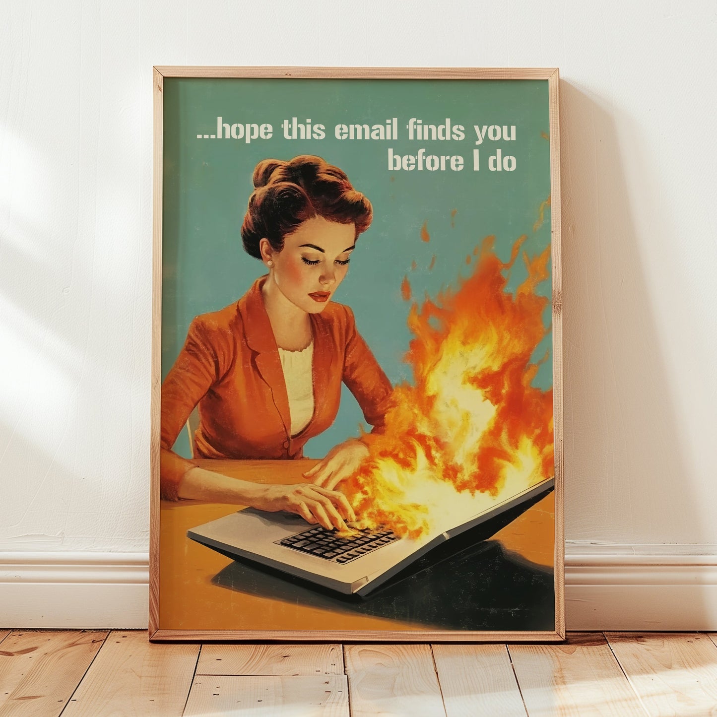 Retro 1950s style woman typing on a flaming laptop with the quote “Hope this email finds you before I do,” funny office wall art for work from home or cubicle decor.