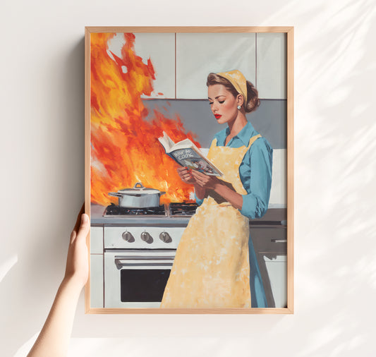 Vintage illustration of a 1950s housewife in a yellow apron calmly reading a cookbook while a fire erupts on a retro stove behind her; funny mid-century modern kitchen wall art.
