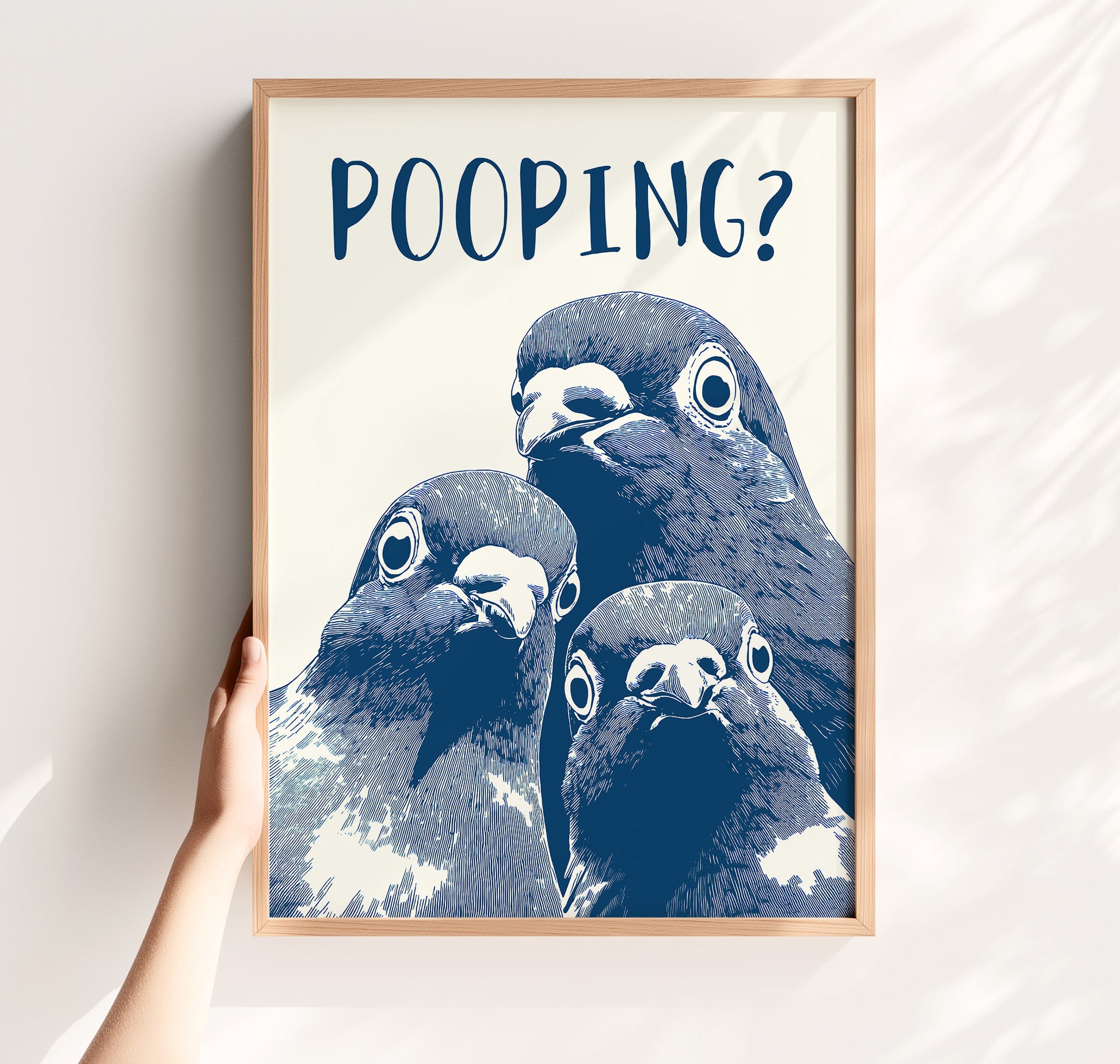 Graphic illustration of three blue pigeons staring directly at the viewer with the word 'POOPING?' written in bold blue text above them; funny bathroom wall art.
