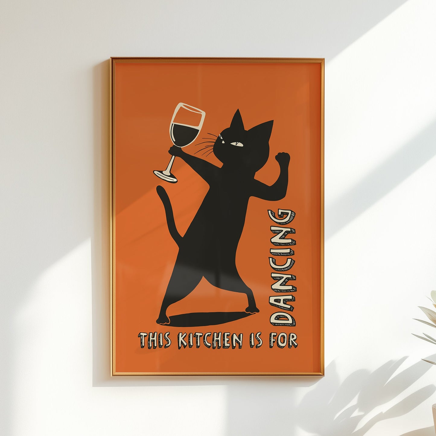 Retro illustration of a sassy black cat dancing while holding a wine glass on a burnt orange background, text reads "This Kitchen is for Dancing" in a vintage font.
