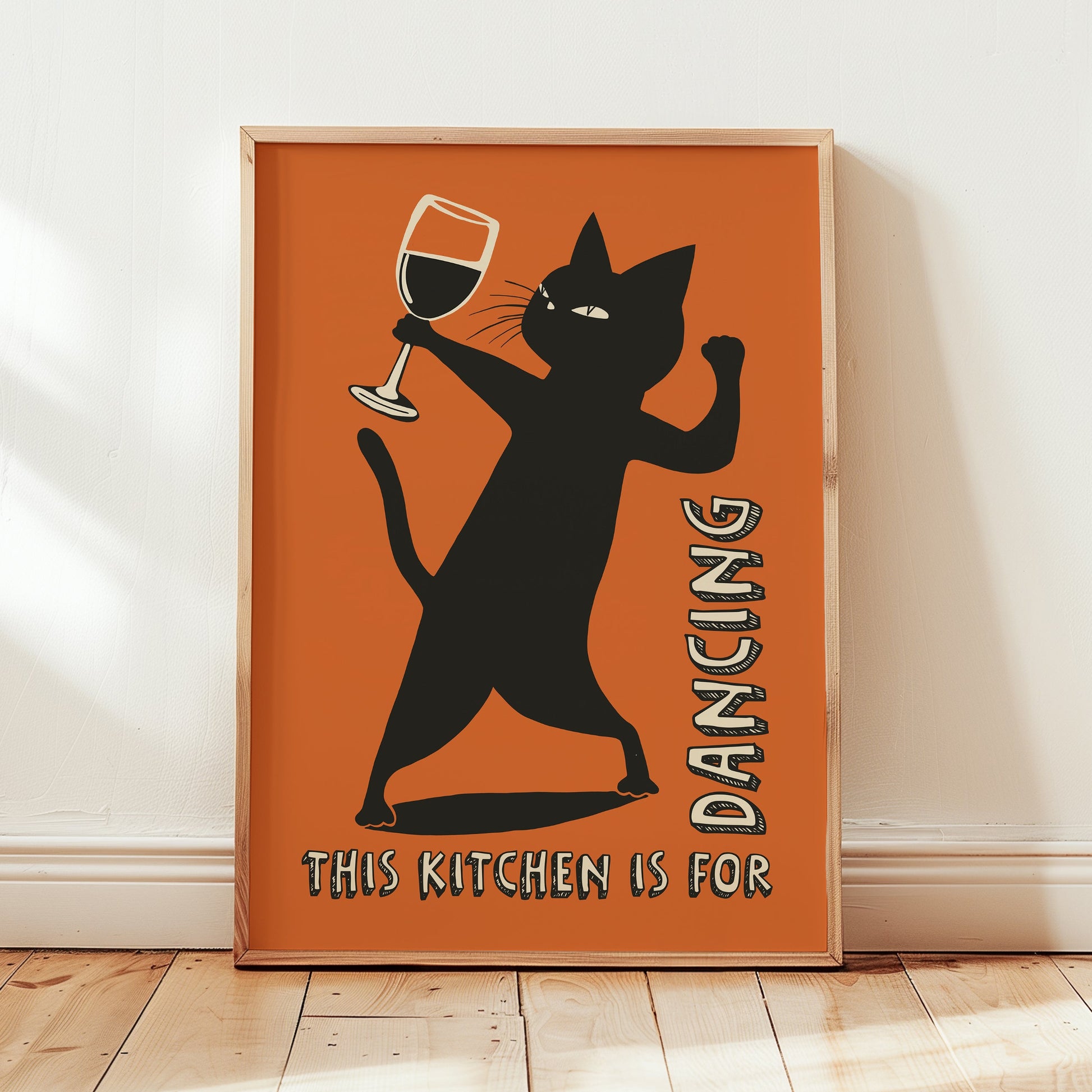 Retro illustration of a sassy black cat dancing while holding a wine glass on a burnt orange background, text reads "This Kitchen is for Dancing" in a vintage font.
