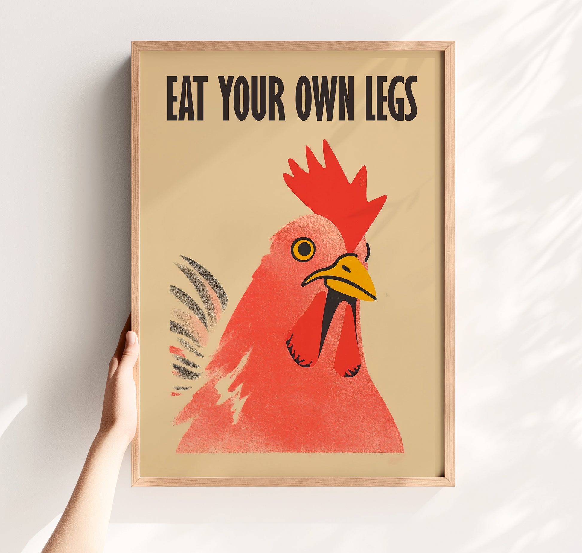 Bold retro illustration of a red chicken rooster with the provocative text "Eat Your Own Legs" in a vintage font, cream background, activist kitchen wall art.
