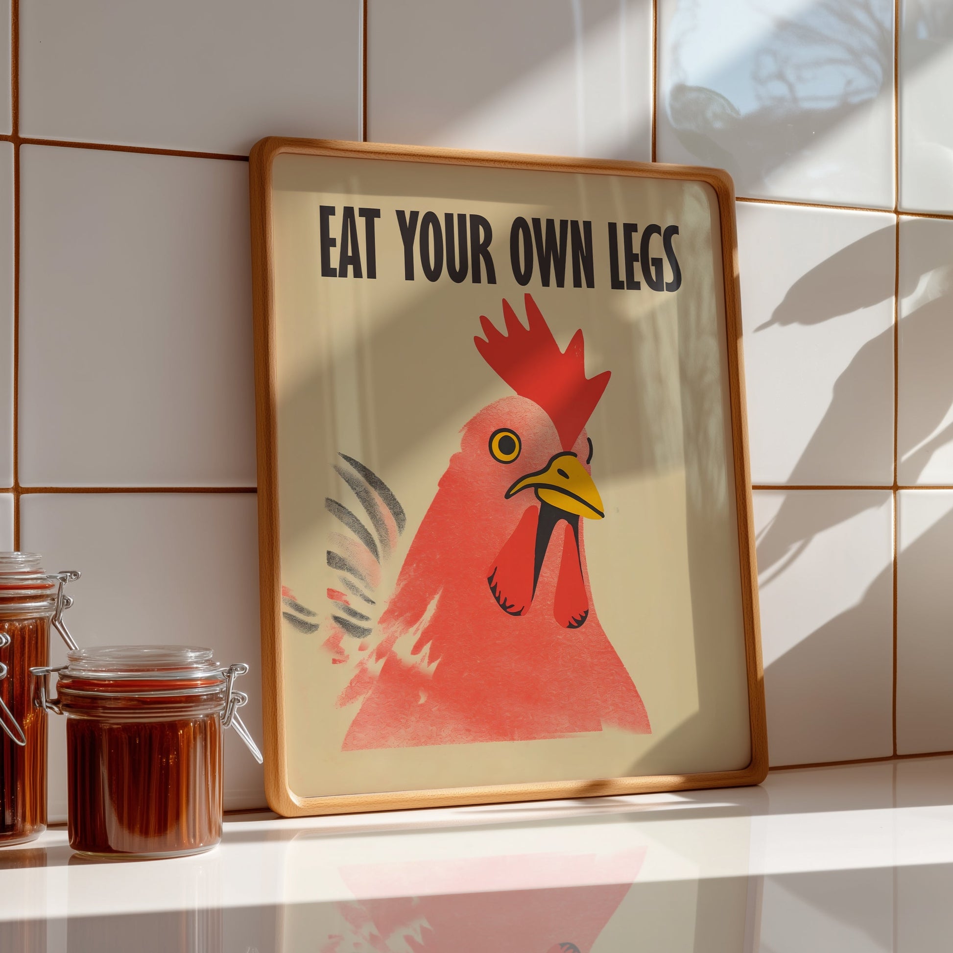 Bold retro illustration of a red chicken rooster with the provocative text "Eat Your Own Legs" in a vintage font, cream background, activist kitchen wall art.
