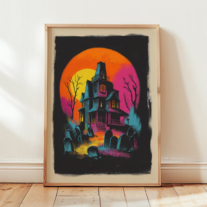A framed art print featuring a spooky haunted house illustration in vibrant neon colors, leaning against a white wall on a light wood floor.