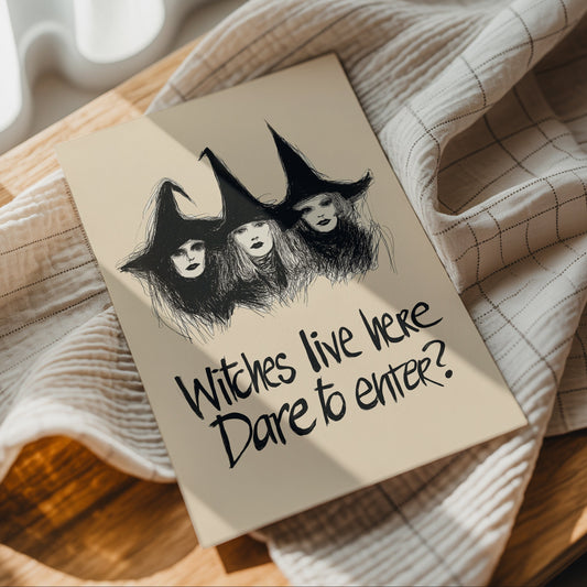 Black and cream Witches Live Here Halloween poster with three hand-drawn witches in pointed hats and the quote “Dare to enter?”