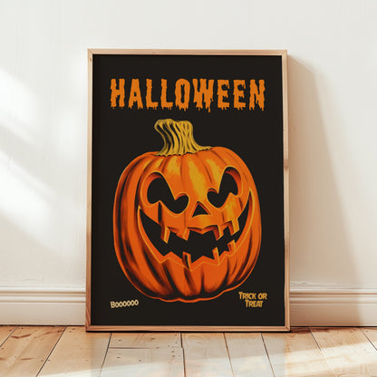 A framed Halloween art print featuring a carved orange pumpkin on a black background with the word 'HALLOWEEN' in dripping orange letters at the top, leaning against a white wall on a light wood floor.