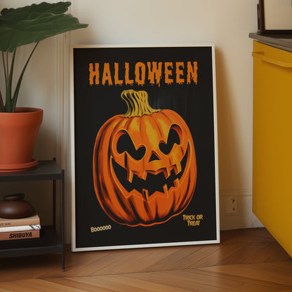 A framed Halloween art print leaning against a wall in a kitchen setting. The print features a large orange jack-o'-lantern pumpkin on a black background with the word 'HALLOWEEN' in orange at the top.