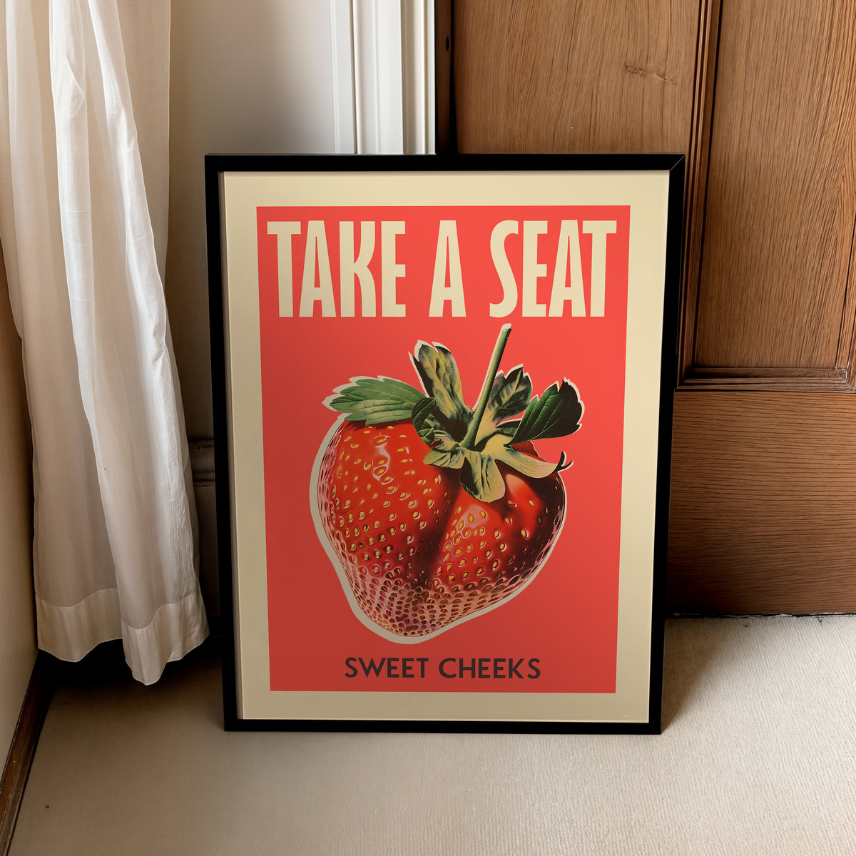 Strawberry bathroom quote print in a black frame, leaning beside a curtain and wooden cabinet.